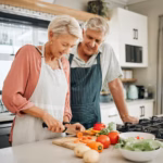 senior-couple-healthy-food-cooking-lunch-together-australia-kitchen-home-happy-woman-hungry-man-retirement-people-cut-vegetables-nutrition-diet-wellness-vegan-dinner-meal_590464-89837